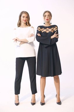 iki model kız resmi kıyafetler içinde - elbise, pantolon ve bluz tüm vücut fotoğrafı beyaza izole edilmiş
