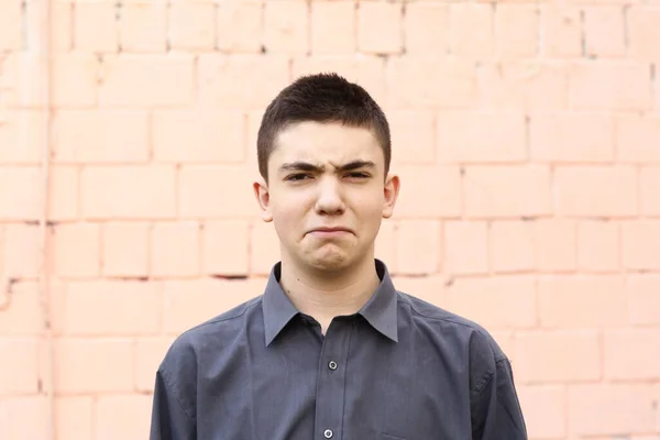 Glücklich Teenager Junge Grimasse Augenzwinkern Nahaufnahme Porträt auf weißem Wandhintergrund — Stockfoto