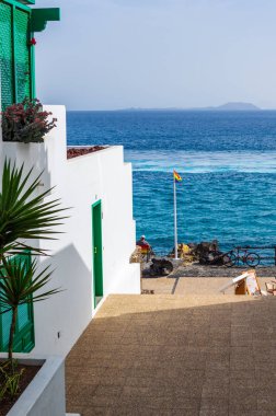 Denize bakan bir adam ile bir sahilde bir gökkuşağı bayrağı bir sonraki