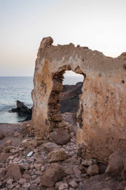 Denize bakan bir uçurumun üzerinde yıkılmış bir binanın kapısı ile Duvar