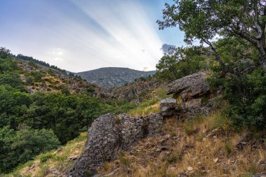 Gün batımında bir dağda gökyüzünde güneş ışınları