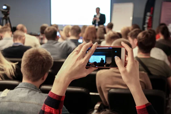 Frau macht während der Konferenz ein Foto mit Smartphone — Stockfoto