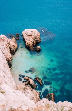 Tenha plaj, deniz dalgaları ve kayalık sahil havadan görünümü