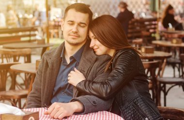 Genç bir çift güneş ışığında sokak kafesinde oturuyor. Romantik randevu.