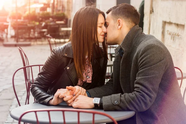 Fiatal pár ül az utcai kávézóban a napkitörésben. Romantikus dátum. — Stock Fotó