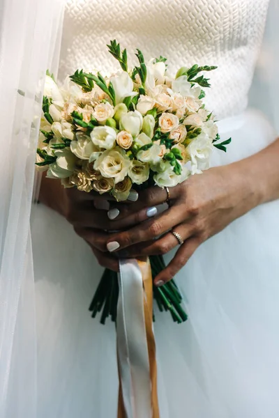 Svatební kytici v rukou nevěsty. Banda malých elegantních květin. — Stock fotografie