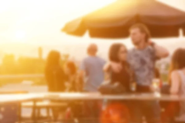 Defocused people attending open air summer party on the roof top