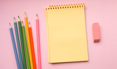 Pembe arka plan üzerinde boya kalemleri ile dikey spiral çizim pedi boş sayfa