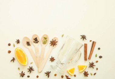 Sıcak şarap malzemeleri düzdü. Tarçın, portakal, kakule, karanfil, anason ve kırmızı şarap beyaz arka planda.