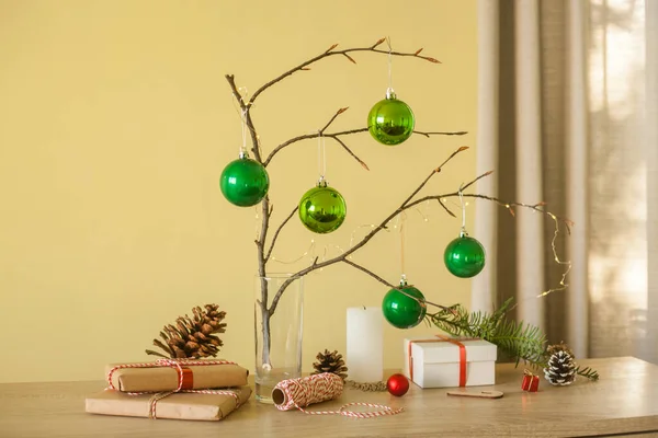 Świąteczne dekoracje. Zielone kulki, gałąź drzewa, pudełka na prezenty, świeca, szyszki sosnowe, Diy pomysł na wystrój wnętrz. — Zdjęcie stockowe