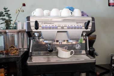 Kahve makinesiyle espresso ve kahve fincanı kafede masanın üstünde. Sabah kahve makinası.