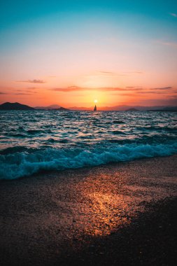 Gün batımında güzel bir deniz manzarasının dikey çekimi.