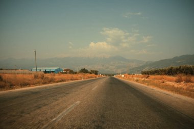 Dağların ortasındaki boş asfalt yolda.