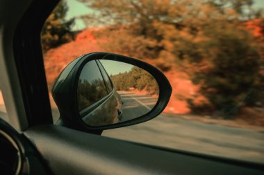 Araba penceresinin dikiz aynası yolda.