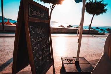 Sahilde güneş ve deniz olan boş bir reklam afişi.