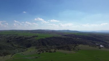 Yeşil tepeleri ve mavi gökyüzü olan güzel bir manzara. Vadinin havadan görünüşü