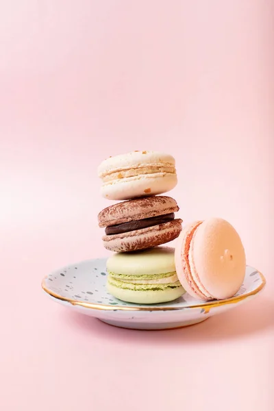 Colorful french macaroons on pink background