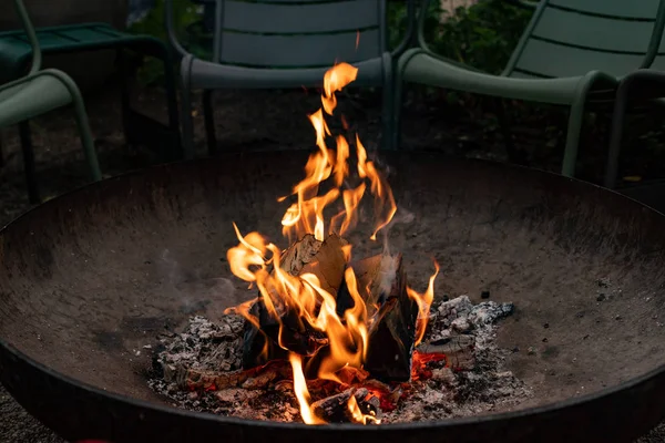 Outdoor metal hearth with fire