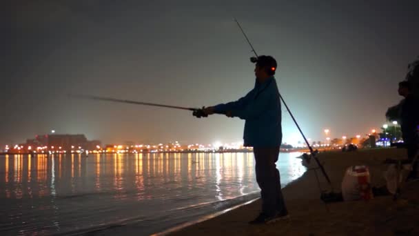 Rybář na pláži v noci Dubaj. — Stock video