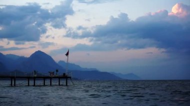 Arka planda dağlar ile deniz gün batımı. Türkiye, Kemer.
