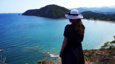 Kızıl saçlı kız Phaselis Akdeniz'de bir tepeden bakar. Antik Likya şehri. Türkiye.