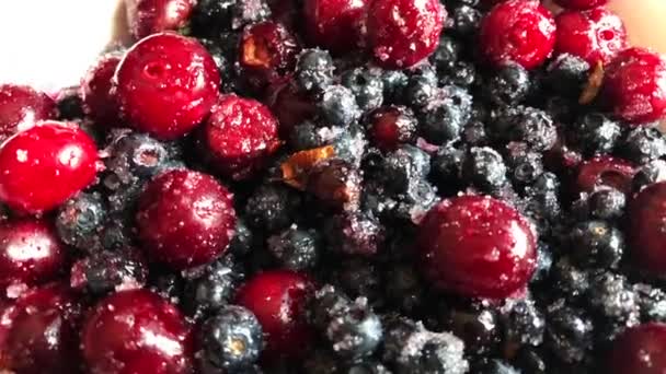 Áfonyák és cseresznyefélék a cukorban és fehér lemezen. — Stock videók