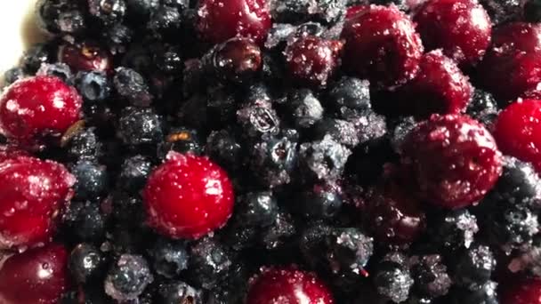 Áfonyák és cseresznyefélék a cukorban és fehér lemezen. — Stock videók