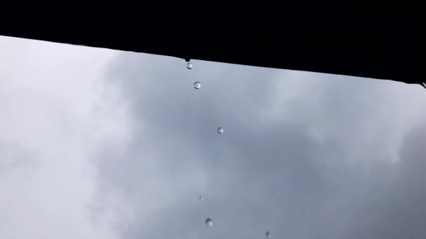 Regn droppar från taket på en molnig dag. — Stockvideo