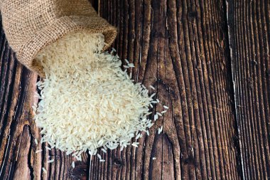 Tahta masadaki çuval bezinden beyaz pirinç döküldü..