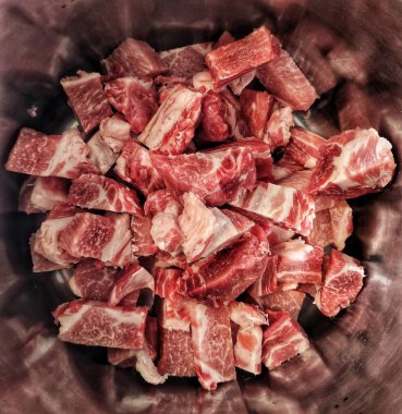 Domuz eti ya da sığır eti bir tencerede parçalara ayrılmış.