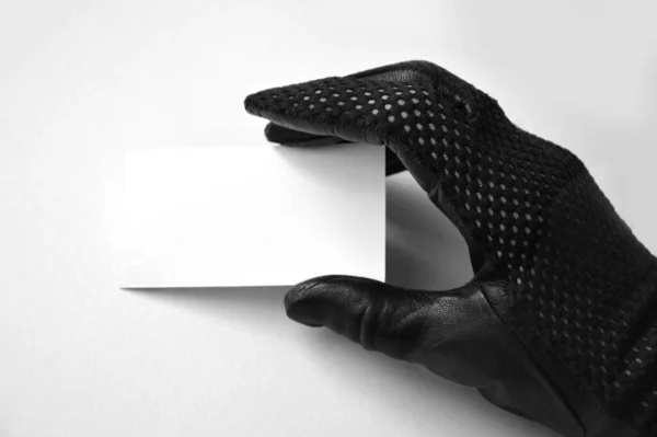 Γυναικείο Χέρι Δερμάτινο Γάντι Από Μαύρο Πλέγμα Κρατά Ένα Λευκό — Φωτογραφία Αρχείου