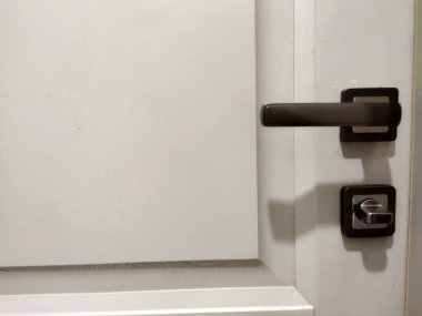 Simple door lock and handle on a clean white door