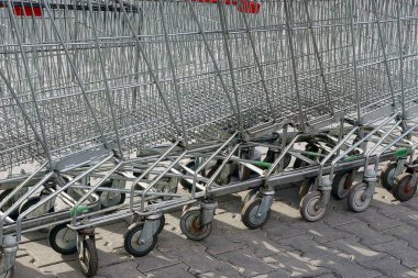 Bir satır bir süpermarket gelen gri alışveriş at arabası sokakta standı