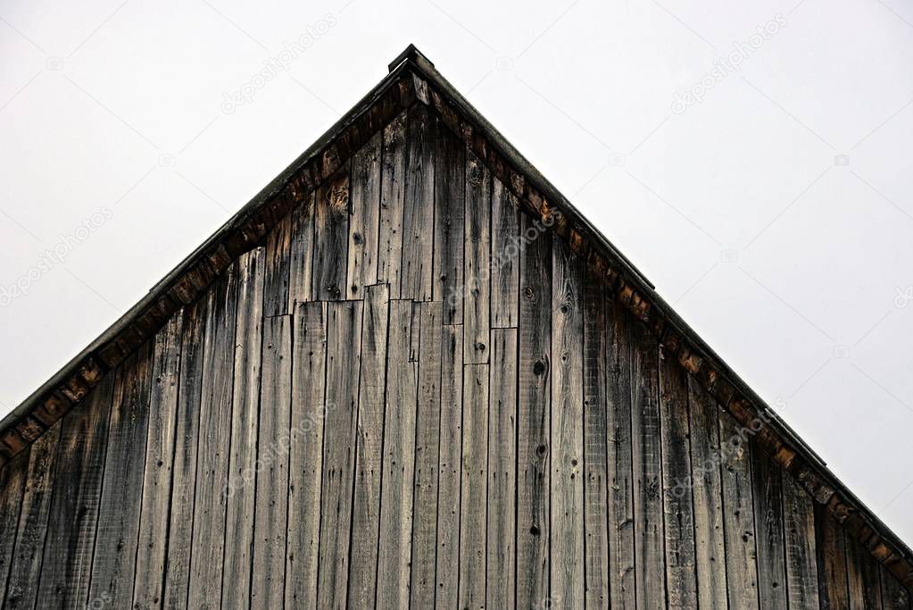 part of an old gray loft of wooden planks against the sky