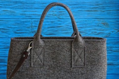 Büyük bir kapalı gri çanta kumaş mavi ahşap bir masa üzerinde yapılan