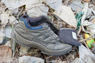 yere çöp arasında eski gri spor ayakkabı