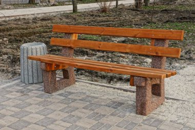 kahverengi ahşap Bank ve gri bir urn kaldırımda Park