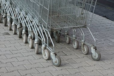 Bir satır bir süpermarket gelen gri alışveriş at arabası stand kaldırımda sokakta