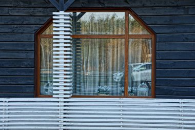 Büyük cam pencere gri bir duvar ahşap kurullarında yapılan