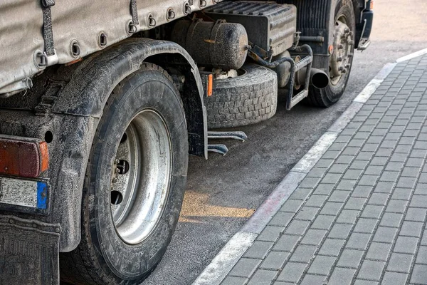 dirty wheels of a big truck on a gray asphalt