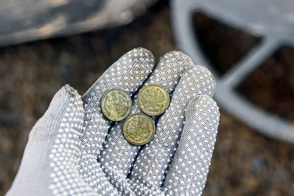 A pile of silver coins above the metal detector coil