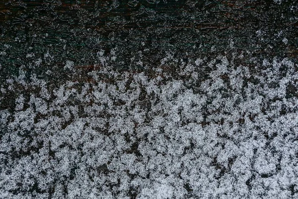 Weißer Schmelzender Schnee Auf Einem Schwarzen Holzbrett — Stockfoto