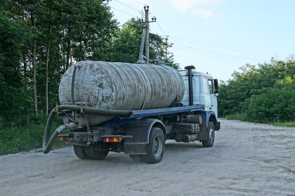 a big dirty truck with a tank and a hose for pumping out road cannonage