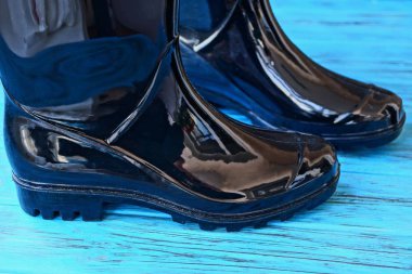 bir mavi ahşap tahta üzerinde iki siyah lastik çizmeler