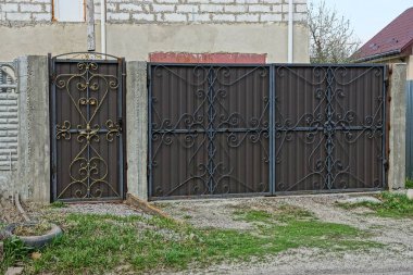 kahverengi bir metal geçit ve sokakta bir siyah deri desenli büyük bir kapı