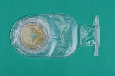 yeşil bir arka plan üzerinde beyaz plastik kolostomi torbası