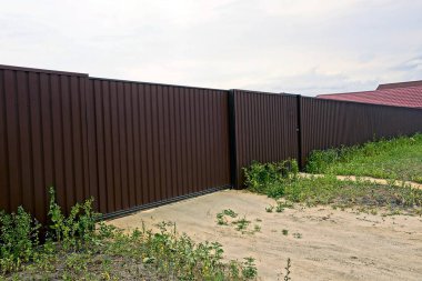 Özel demir kahverengi çit ve güneşli bir gün sokakta yeşil çim kapıda bir parçası