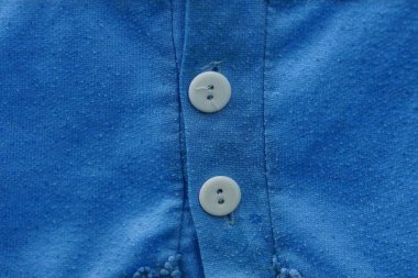 mavi kumaş elbise parçası üzerinde iki beyaz düğme