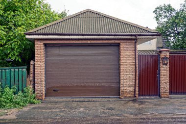 Özel bir garaj ve bir Iron gate road yakınındaki bir posta kutusu ile kahverengi kapı