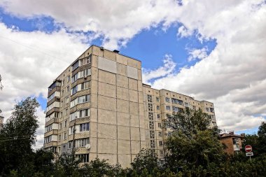 Gri paneli apartman ağaçlar ve yeşil bitki örtüsü gökyüzünde karşı